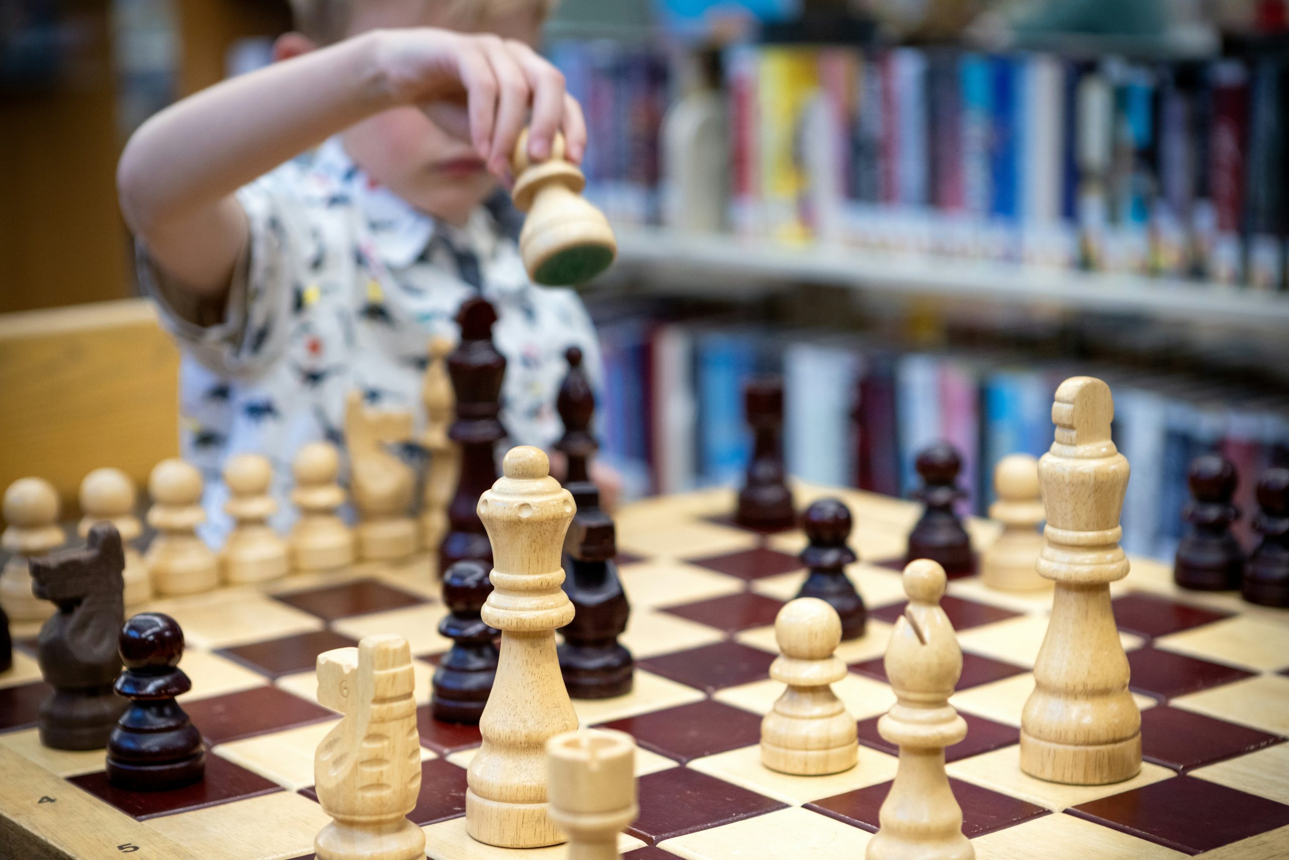 Young pupil concentrating while playing chess